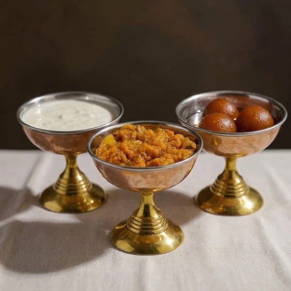 Three ornate copper and brass bowls filled with Indian desserts: kheer, halwa, and gulab jamun.